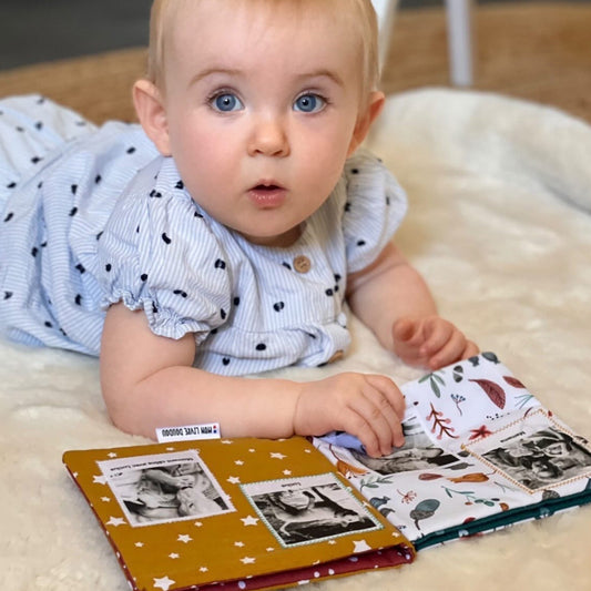 Bébé observe avec attention les contrastes et couleurs de son livre doudou personnalisé