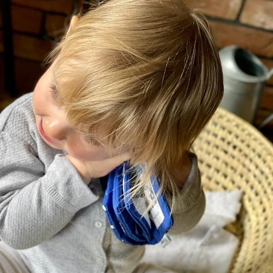 Bébé serrant son livre doudou personnalisé pour s'apaiser pendant la séparation