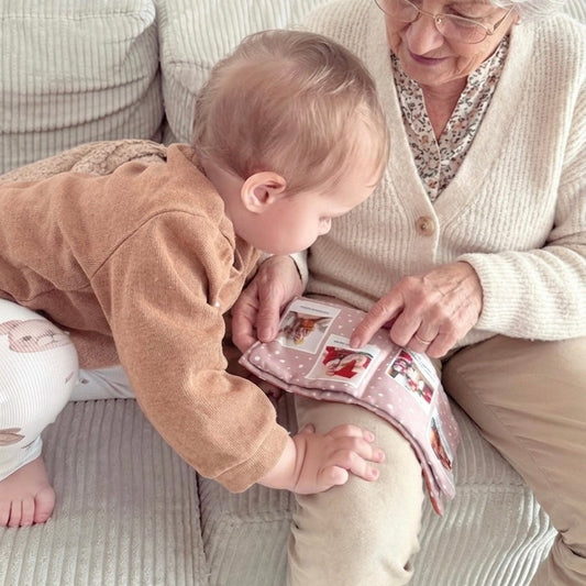 Bébé feuilletant son livre doudou avec les photos de ses grands-parents éloignés