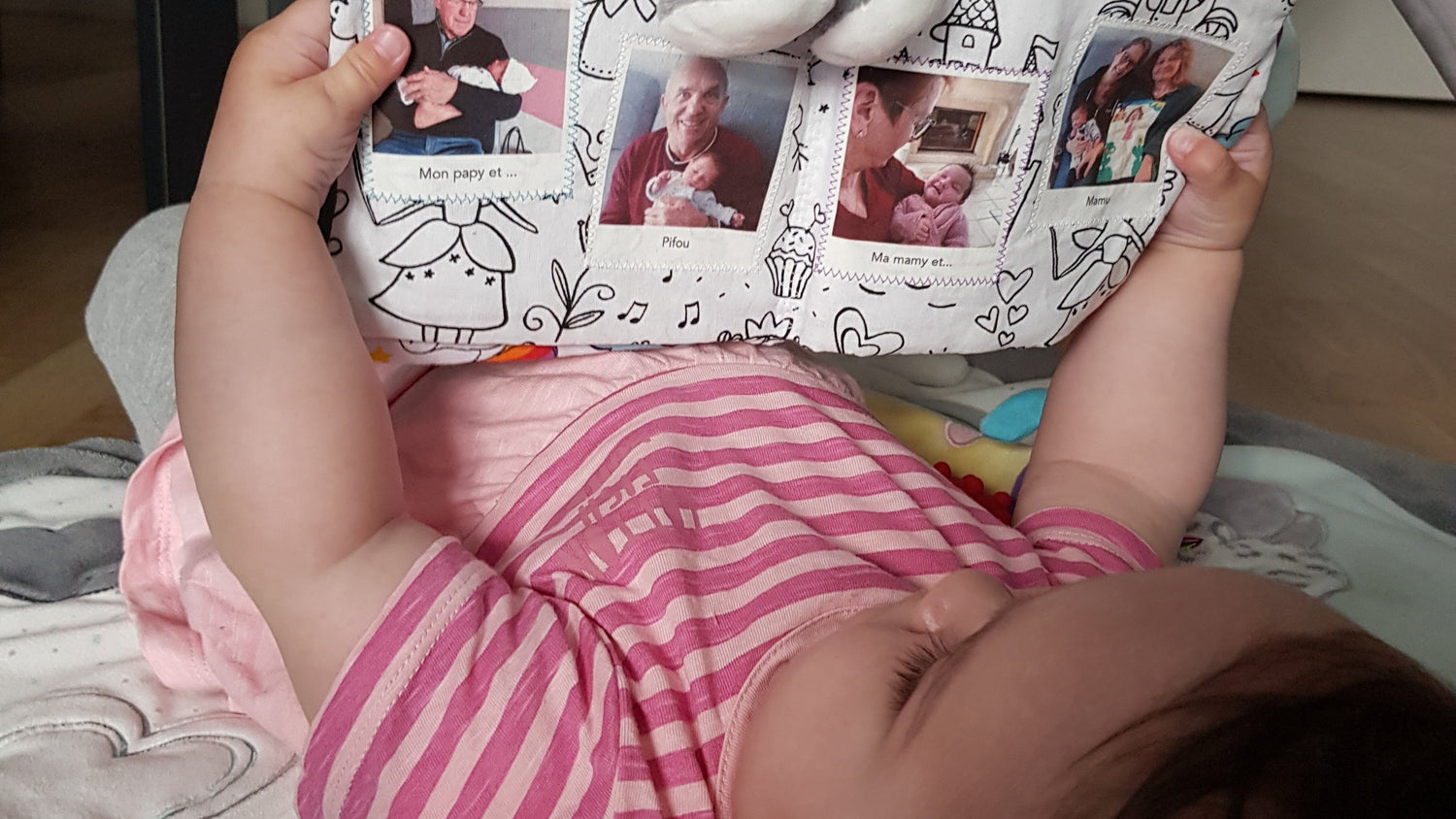 enfant en train de regarder les photos de sa famille sur un album en tissu